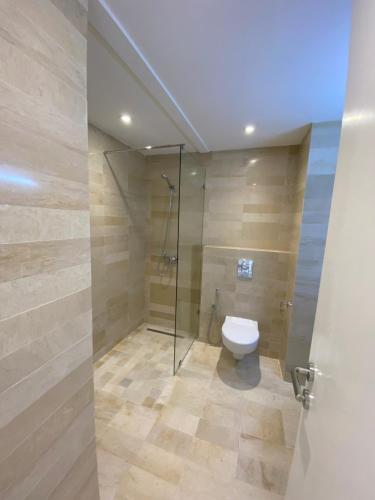 a bathroom with a toilet and a glass shower at Résidence Neffati in Hammamet