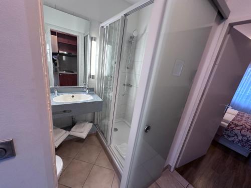 a bathroom with a glass shower and a sink at Apartment-Hotel Hamburg Mitte in Hamburg