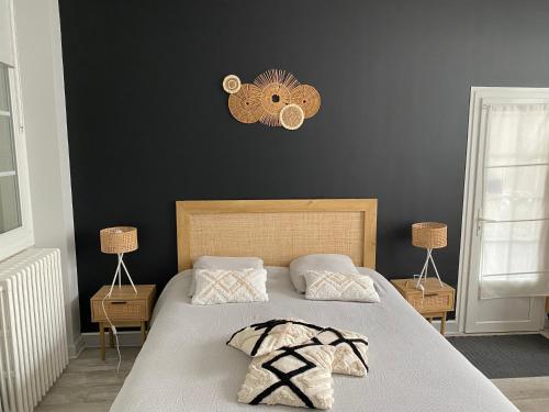 um quarto com uma cama e um relógio na parede em Les Cottages de la Norge em Clénay
