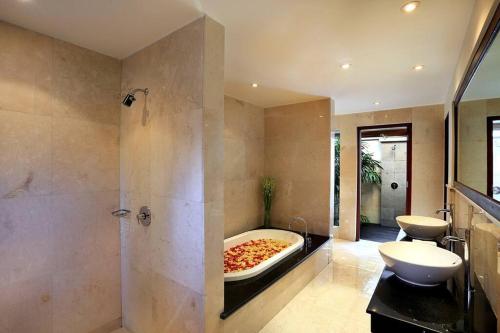 uma casa de banho com uma grande banheira com uma pizza em Jimbaran Luxury 4BR with Butler em Jimbaran