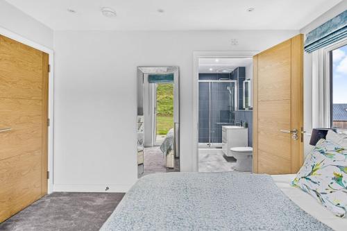 a bedroom with a bed and a bathroom at No 8 The Vista, Willingcott, Woolacombe in Woolacombe