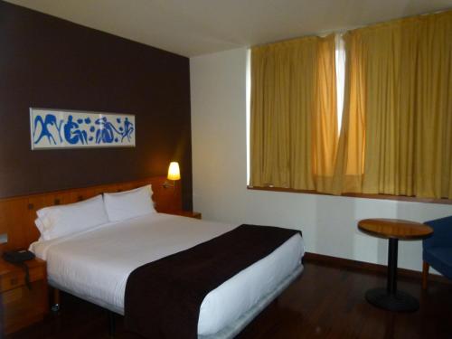a hotel room with a bed and a window at Hotel Viladomat in Barcelona