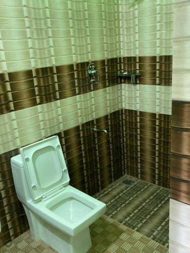 a bathroom with a toilet and a shower at MO’s Agro in Pāppinisseri