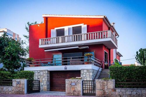 a red house with a balcony on top of it at Villa Marbella by Slow Villas in Playa de Palma