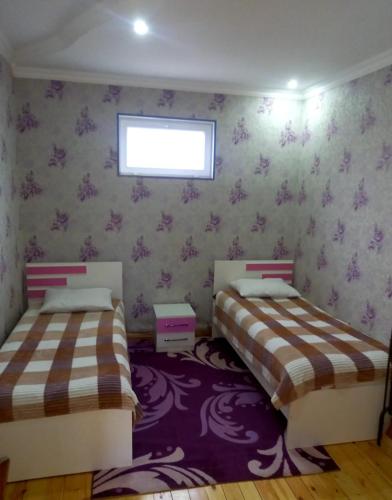 a bedroom with two beds and a purple rug at Gabala villa Exceptional in Gabala