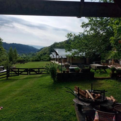 a view of a field with a tent and picnic tables at Camping Sretanwolf in Bosiljevo