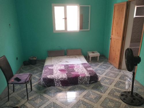 - une chambre avec un lit dans une pièce verte dans l'établissement Dar Daoudi, à Nouakchott