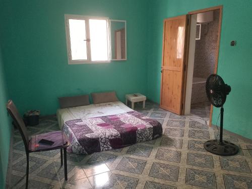 ein Schlafzimmer mit einem Bett und einem Ventilator in einem Zimmer in der Unterkunft Dar Daoudi in Nouakchott