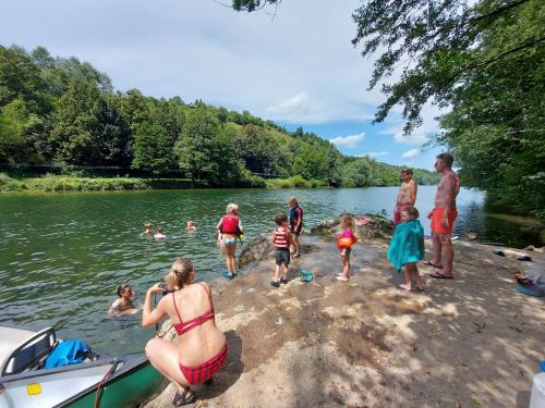 a group of people standing on the shore of a lake at Camping Sretanwolf in Bosiljevo