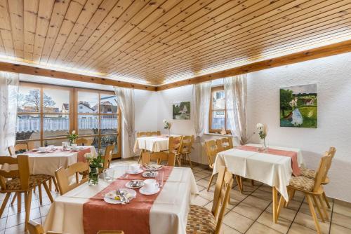 a dining room with tables and chairs and windows at Ferienhaus Toni in Hohenstein