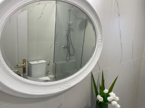 a white bathroom with a mirror and a shower at Neptune family Villa in Zakynthos Town