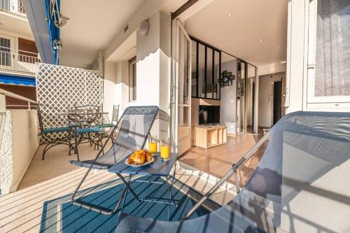 une table en verre et des chaises sur un balcon dans l'établissement 3 VIDAL - Splendide appartement 4 couchage hyper centre de Cannes, à Cannes