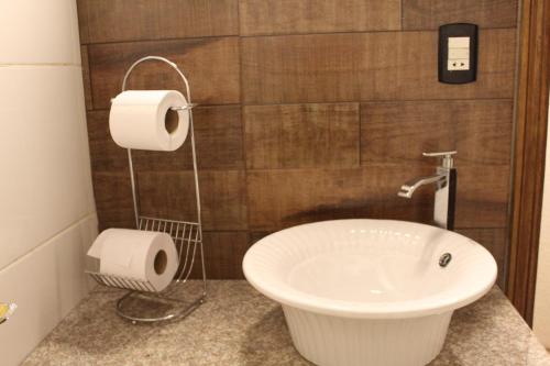 a bathroom with a sink and a toilet paper dispenser at AP 40- Apart OH in Ciudad del Este