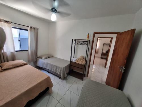 een kleine slaapkamer met 2 bedden en een spiegel bij Casa nova e confortável próxima ao Santuário in Aparecida