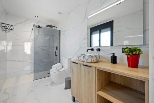 a bathroom with a sink and a toilet and a mirror at La Villa del Roc in Roda de Bará