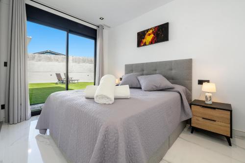 a bedroom with a bed and a large window at La Villa del Roc in Roda de Bará