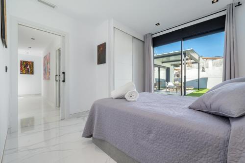 - une chambre avec un lit et une grande fenêtre dans l'établissement La Villa del Roc, à Roda de Bará