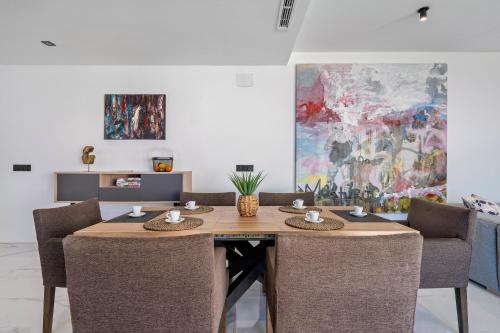 a dining room with a wooden table and chairs at La Villa del Roc in Roda de Bará