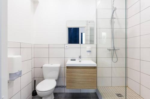 a white bathroom with a toilet and a sink at Ephemoria - Appartement familial proche Cathédrale in Reims