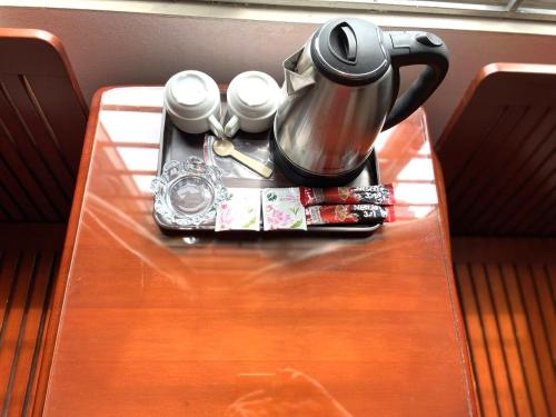 a table with a tea pot and cups on it at Hong Ha Airport Hotel in Thach Loi