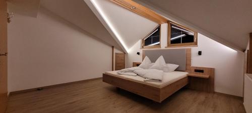 um quarto com uma cama com almofadas brancas em Appartementhaus Florian em Längenfeld