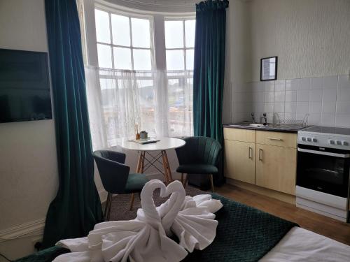 a room with a kitchen with a table with a swan at SeaView ground floor flat fast WiFi & FREE PARKING in Scarborough