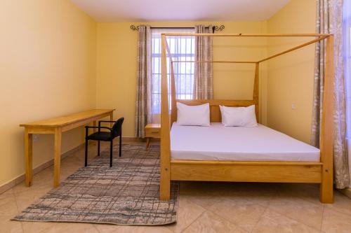 a bedroom with a bed and a desk at OLMOTI SUITES in Arusha