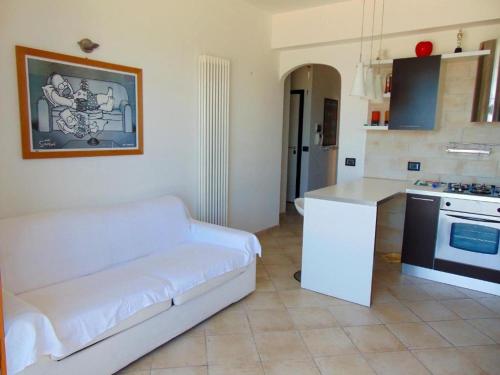 a living room with a white couch and a kitchen at Trilocale fronte mare a Marcelli - M210 in Marcelli