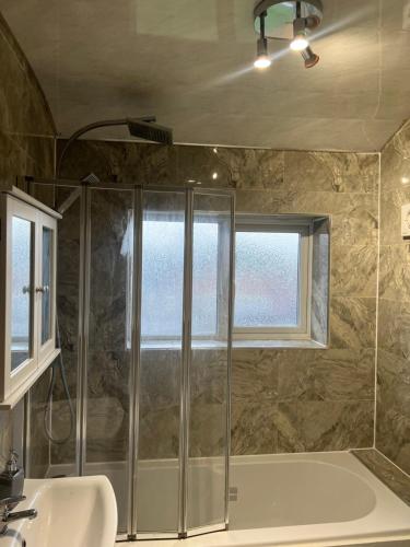 y baño con ducha y lavamanos. en Five Oaks House- Entire 3 Bedroom House for Family & Contractors with up to 5 sleep- NO PARTIES ALLOWED en Willenhall