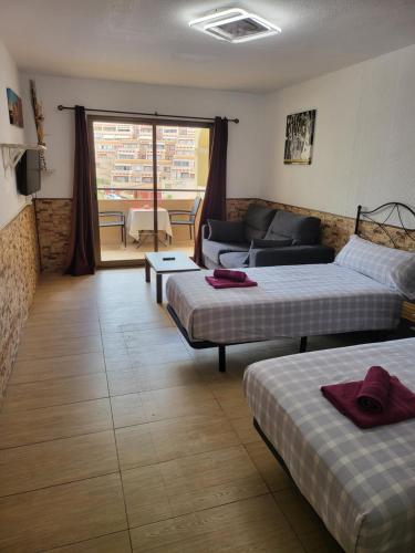a living room with two beds and a couch at Tropic Apartments en Castle harbour in Los Cristianos