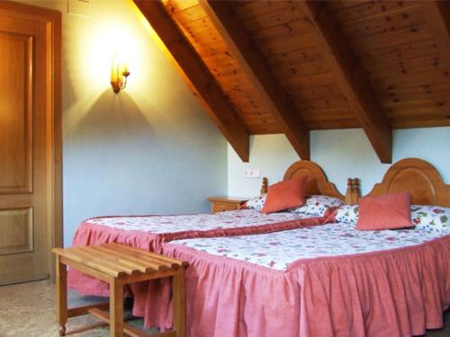 a bedroom with two beds and a wooden ceiling at Hotel Turrull in Vielha