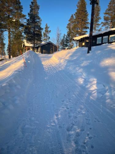 masę śniegu z domem w tle w obiekcie 1125 Fjällstugan w mieście Lofsdalen