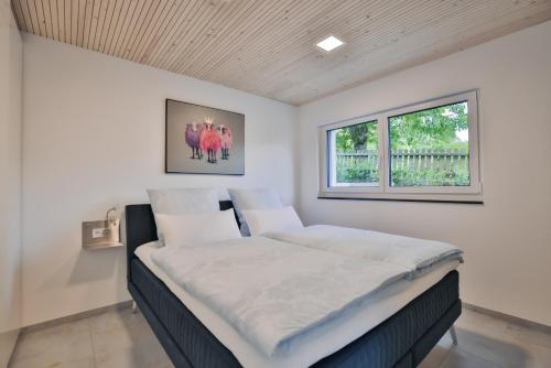 a large bed in a room with a window at Purer Genuss - Garten und Alpe in Owingen