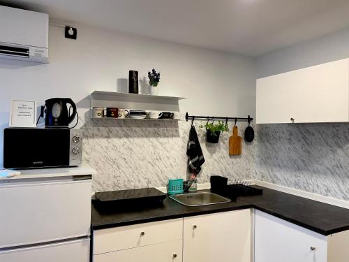 a kitchen with white cabinets and a black counter top at Apartments Nina in Koper