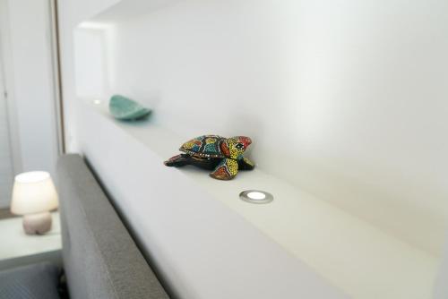 a small toy turtle sitting on the edge of a couch at Ponente & Maestro Rooms in Favignana