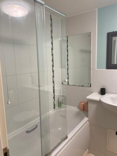 a white bathroom with a shower and a sink at Spacious Apartment near Heathrow with Allocated Parking in Uxbridge