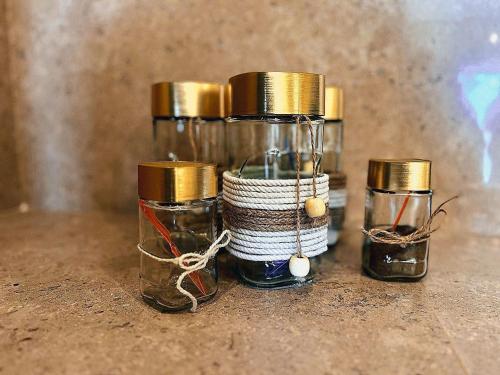 three glass jars with gold tops on a table at Azzura appartment sahl hashesh with private garden in Hurghada