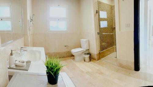 a bathroom with a toilet and a sink and a shower at Azzura appartment sahl hashesh with private garden in Hurghada