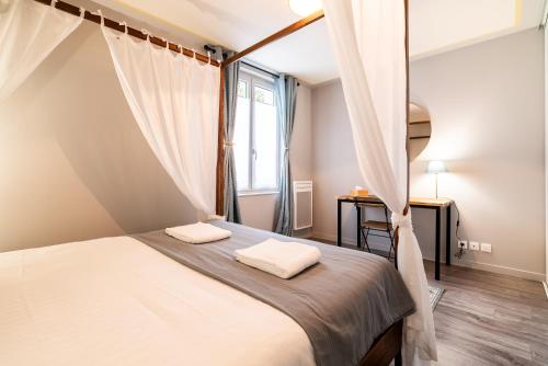 a bedroom with a canopy bed with a window at Mon Appart'hôtel - Gare de Limoges - Charmant 1 et 2 Chambres Duplex - Parking en supp in Limoges