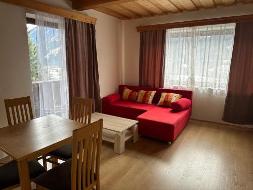 sala de estar con sofá rojo y mesa en Sissi Apartment en Ausserfragant