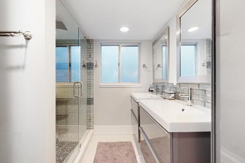 a white bathroom with a sink and a shower at Gather Together - Unit 145 in Marco Island