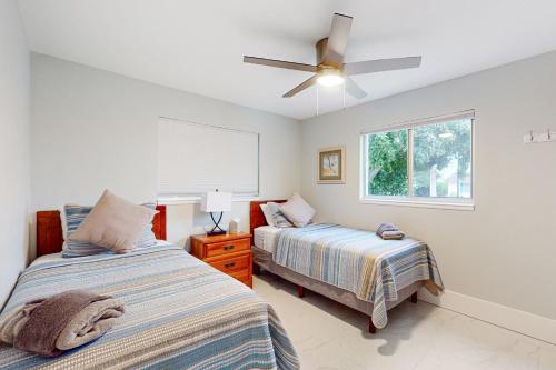 a bedroom with two beds and a ceiling fan at Gather Together - Unit 145 in Marco Island