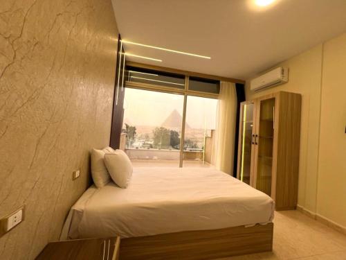 sypialnia z dużym łóżkiem i oknem w obiekcie Giza Pyramids View Inn w Kairze