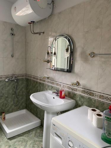a bathroom with a sink and a mirror at Itan’s apartments in Tirana