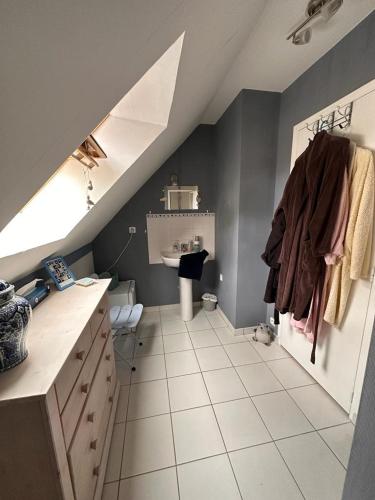 a attic room with a bathroom with a sink at 13-Mésanges in Changé