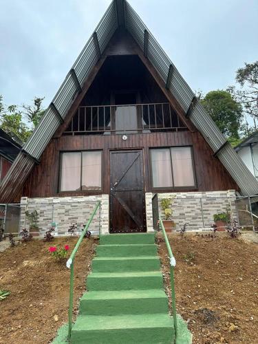 a house with a staircase leading to a door at Bungalows Tenorio Montand Lodge in San Rafael