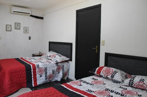 a bedroom with two beds and a black door at AP 80- Apart OH in Ciudad del Este