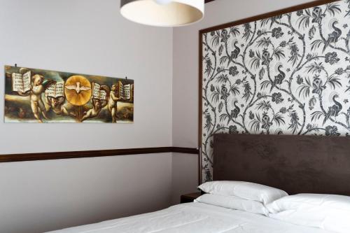 una camera da letto con un dipinto sul muro accanto a un letto di Affittacamere Le Dimore del Riccio a Foggia