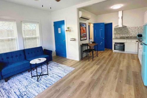 a living room with a blue couch and a kitchen at Luxury 1 Bd Montrose - Genova at The Italian Plaza in Houston