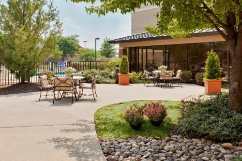 a patio with tables and chairs in a garden at Staybridge Suites Allentown Airport Lehigh Valley by IHG in Allentown